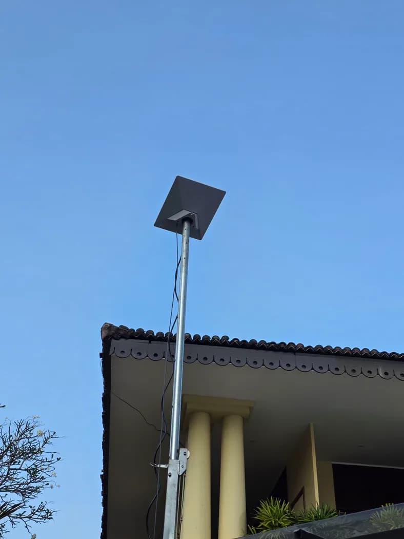 Starlink Mini dish raised high on the mast against the city skyline